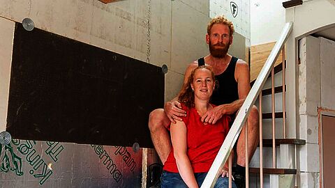 Nick en Patrick zitten op de trap in hun nog te verbouwen huis.